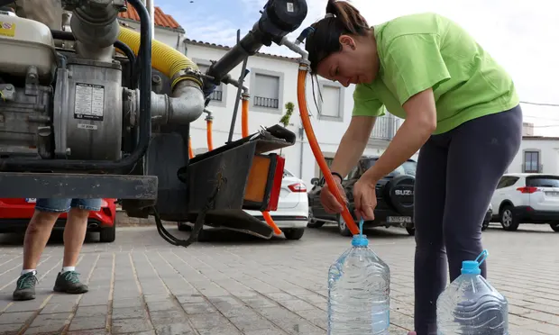 27 April 2023: Temperatures in Spain hit record highs and exceed 40 ºC (104 ºF). A woman fills bottles with drinking water from a truck after the local reservoir nearly dried out in Alcaracejos. Image: Reuters