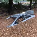 Car buried under river stones